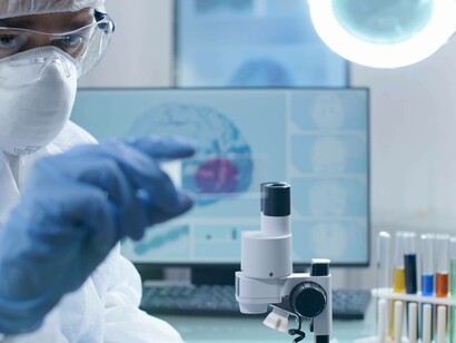 Ricercatore con in mano un vetrino del microscopio per l'analisi di un campione di sangue 