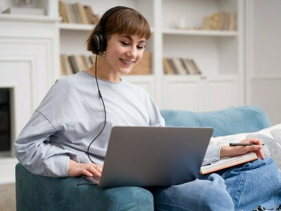 A woman attending an online course at home, combining technology and education through a Zoom lecture