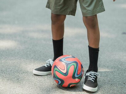 Nossa visita ao estádio era memória e lição. Entre um chute e outro, crianças corriam pelas ruas, chutavam tampinhas de garrafa como gols impossíveis — alquimia de azar e esperança