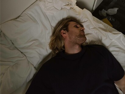 A man recovering from a broken heart is reflecting in bed
