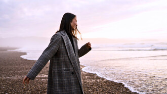 A woman enjoying the beach alone, showing that solitude can feel freeing