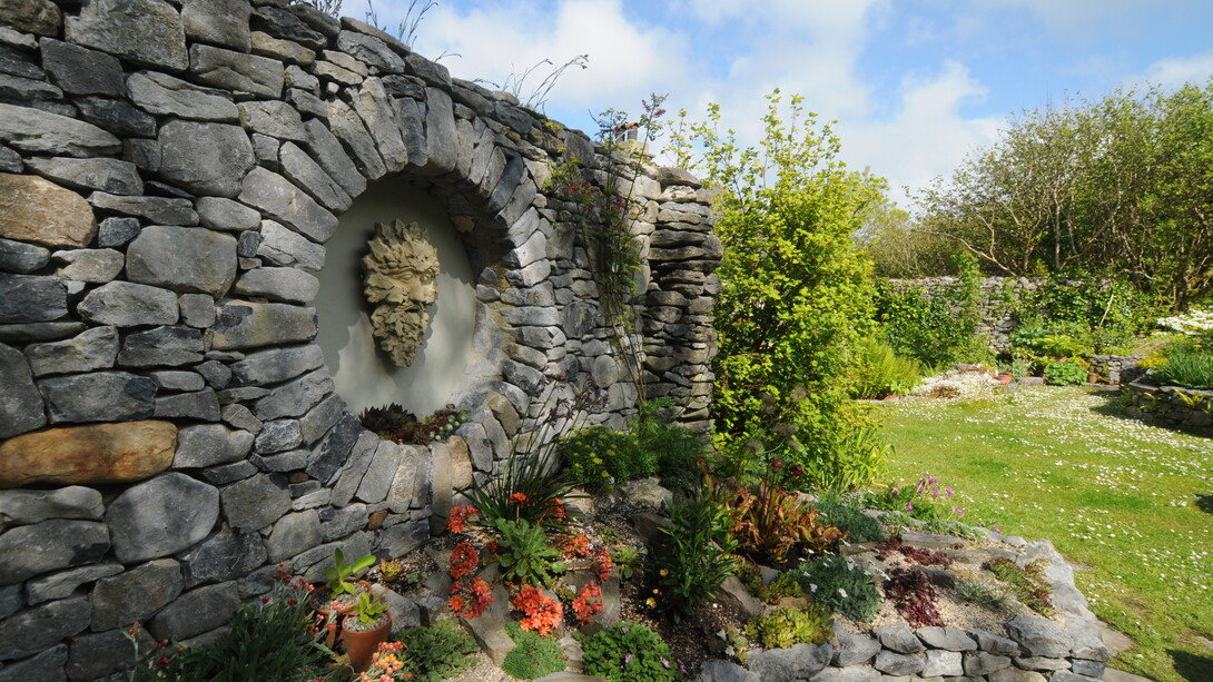 Ai piedi del muro in pietra, Carl Wright ha ambientato una collezione di sedum e semprevivi e di piccole piante alpine tra cui numerose specie di primula. Foto di Enzo Valenti