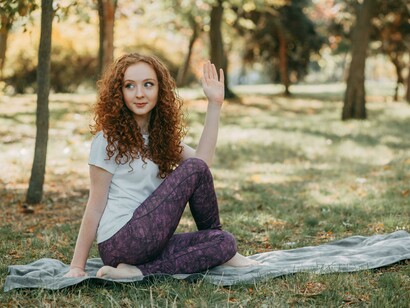 Yoga practice in the park with a woman stretching on the grass
