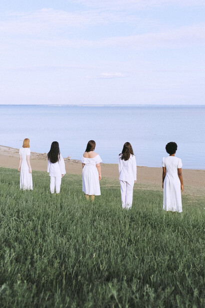 Ragazze con abiti bianchi guardano il mare: possiamo tornare ad immergerci nel grande oceano della vita