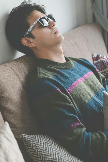 Man laying back on couch with sunglasses