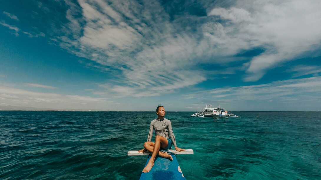 A woman wearing a rash guard in the sea in the Philippines, enjoying a peaceful travel moment