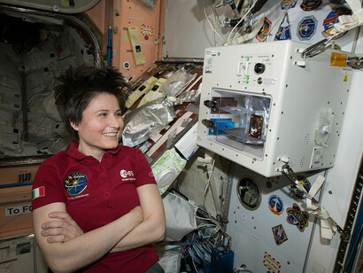 Samantha Cristoforetti vicino alla macchina ISSpresso