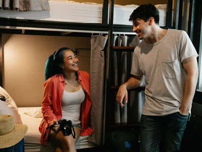 Solo travellers sharing stories in a communal space, reflecting how modern hostels are designed to foster community