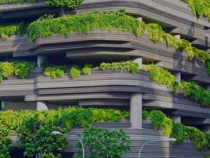 A gray concrete building in Singapore is covered by trees