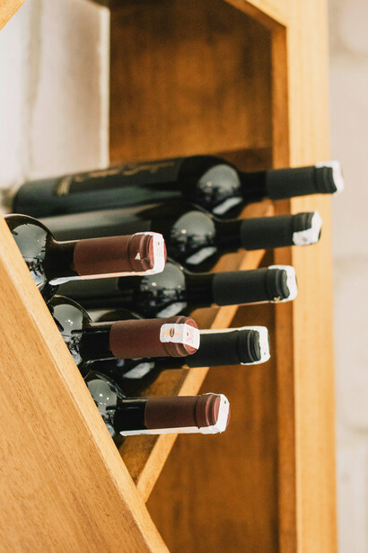 A collection of wine bottles on a brown wooden shelf