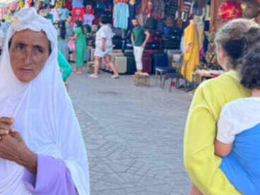 Dans les allées mouvantes de la médina, certains regards semblent porter toute la mémoire marocaine de Marrakech. Entre les étoffes suspendues et la lumière écrasante, la ville continue de raconter ses histoires à voix basse