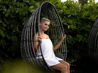 Relaxing at a spa in a sustainable boutique hotel, a woman experiences eco-friendly hospitality and innovative green architecture in a serene setting