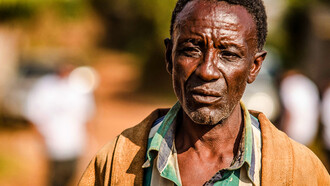 The weight of the world is etched in the lines of his face, a testament to a life shaped by hardship and struggle