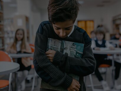 Menino triste enquando caminha pela escola onde sofre bullying