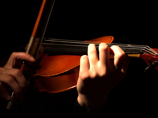 Acercamiento a las manos de una mujer tocando el violín