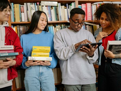 A man and a woman talking inside a library, both exchange students