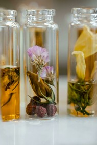Clear glass perfume bottles filled with liquid and decorated with dried flowers
