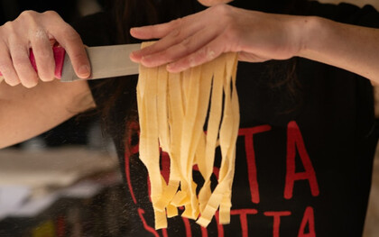 La résistance se savoure : dans La Pastasciutta antifascista, chaque geste compte. Ici, les bras d’une interprète révèlent les spaghettis fraîchement coupés, symbole d’un acte quotidien devenu acte de liberté et de partage