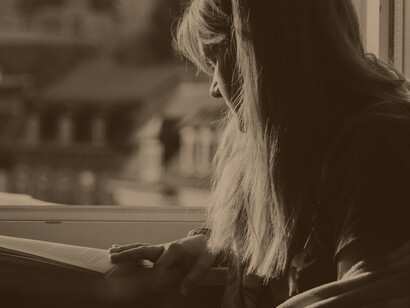 Mujer leyendo junto a la ventana