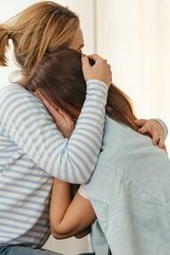 Woman hugging crying tween child