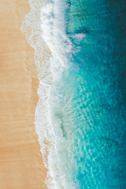 A água cristalina encontra a faixa de areia em uma composição marcada por diferentes tons de azul e dourado. Diante de paisagens assim, a viagem deixa de ser apenas deslocamento e passa a ser uma experiência de descoberta interior