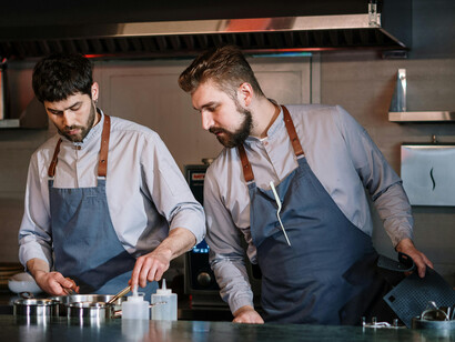 Two professional chefs work in the kitchen of a luxury restaurant