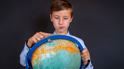 Menino estuda o globo