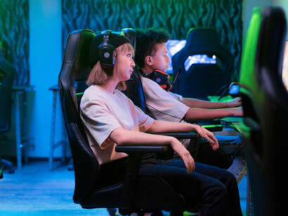 People playing on computers in a 2000s-style internet café