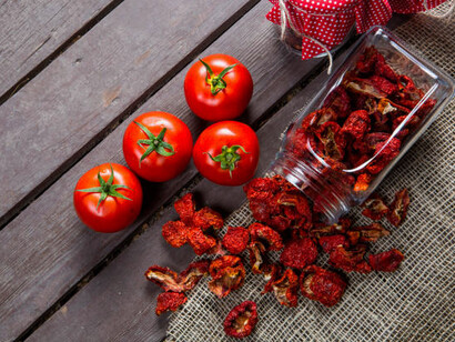 Fresh tomatoes and sun-dried organic tomatoes make for healthy snacks, showcasing the benefits of conventional drying methods