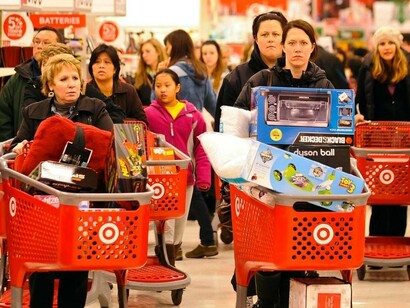 Una fila de clientes aguarda con sus carros cargados de productos en un día de ofertas