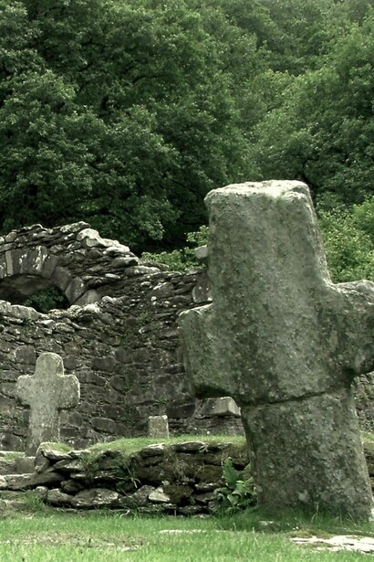 Vista de la icónica torre circular y las ruinas medievales del asentamiento monástico de Glendalough, fundado por San Kevin en el siglo VI en Glendalough, Irlanda 