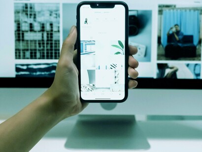 Pessoa trabalhando com celular e computador ao mesmo tempo. Outro problema é o impacto no sono. A luz azul emitida pelas telas interfere no ritmo circadiano, dificultando o adormecimento e afetando a qualidade do sono