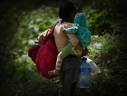 Mujer con su hijo en brazos cruza el Tapón del Darién, conocido por ser un cruce irregular de inmigrantes que intentan llegar a los Estados Unidos