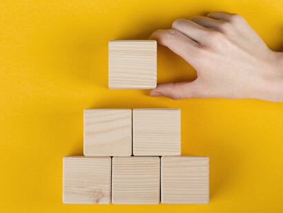 The wooden blocks are rearranged, reflecting the iterative nature of problem-solving, where solutions must be adjusted and refined as new information emerges
