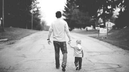 Un padre y su hijo avanzando por la vida de la mano
