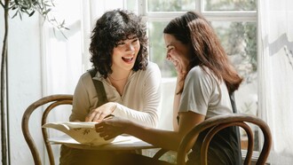 A couple of friends sharing a laugh during their break at their workplace