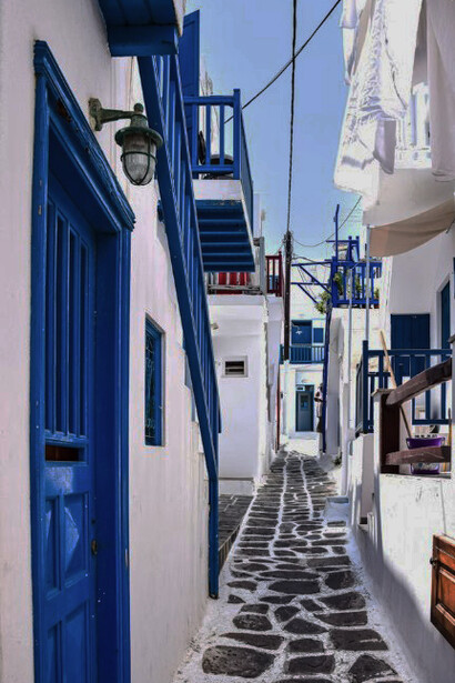 A white and blue concrete building stands in stark silence, echoing the emptiness spreading across the Greek islands as homes are left unoccupied