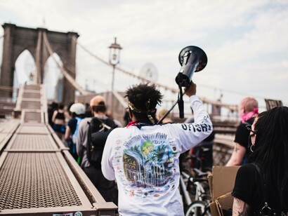 Protestor with a megaphone guiding people on the Brooklyn Bridge in New York, USA