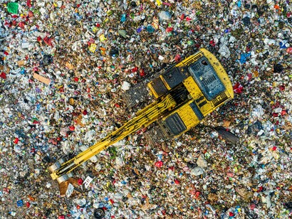 Vista aérea de operações de manejo de resíduos mostra a complexidade logística envolvida no tratamento do lixo. A centralização do descarte contrasta com propostas que priorizam a valorização local da biomassa