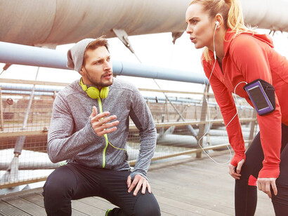 A joyful couple engaging in long-distance running outdoors, sharing an active workout