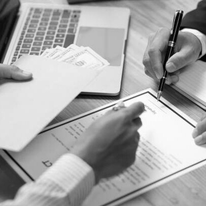 A businessman taking cash and a brown envelope from a folder, representing workplace bribery and corporate corruption