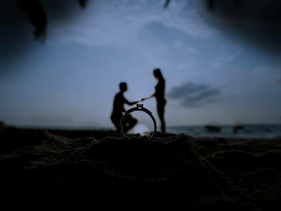 A marriage proposal on a beach during sunset