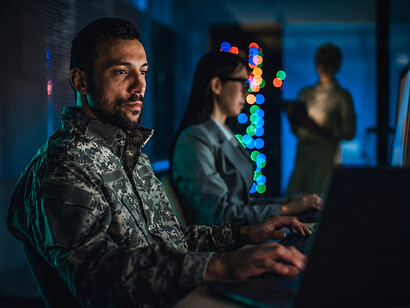 Military and civilian cybersecurity professionals collaborating in a modern cybersecurity operations cente