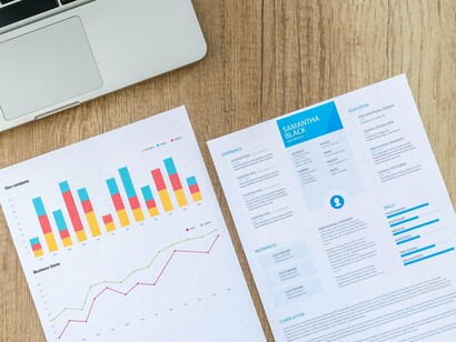 A candidate’s resume laid next to a corporate graph, reflecting the shift toward data-led hiring decisions