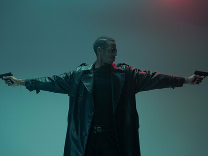 A leather-clad figure prepared for battle with arms outstretched, symbolizing the rebellion against systems of control at the heart of The Matrix