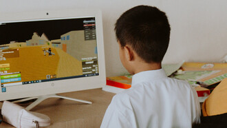 Aluno em sala de aula joga rpg no computador