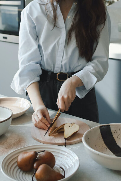 Donna in cucina mentre taglia della frutta 