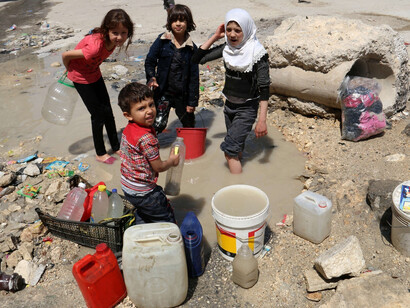 Niños en Siria recogiendo agua insalubre