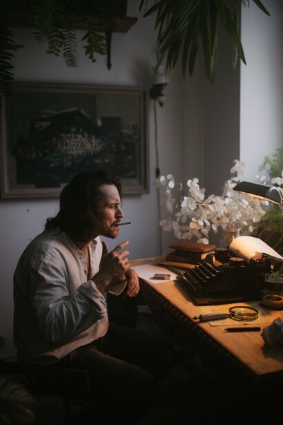 A poet working at his desk on a typewriter 