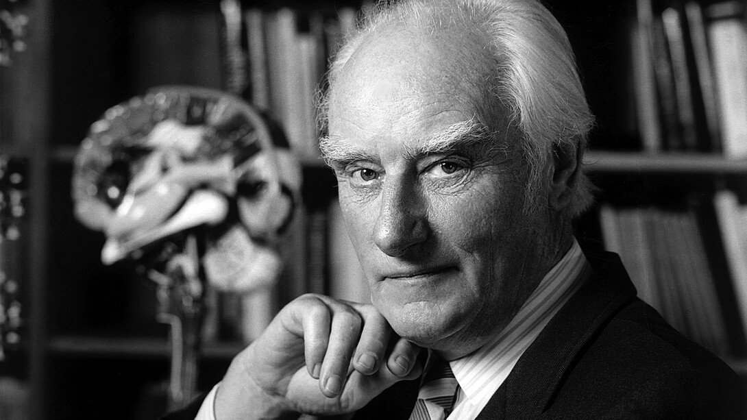 Francis Crick stellte das zentrale Dogma der Molekularbiologie auf: Informationen fließen von der DNA zur RNA und weiter zu den Proteinen, die die Maschinerie des Lebens bilden. Bild: Francis Crick in seinem Büro. Aufnahme um 2004